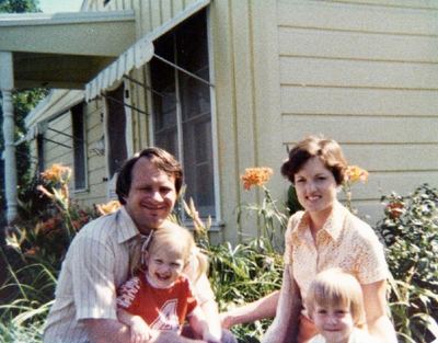 LaVonne Danielson with family beside a clapboard house