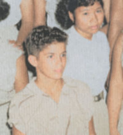 Restored and colorized (AI-assisted); faces are the original photo, colours are a best guess. Bill Proeger (enrolled as B. Roberts), freshman class, George Washington High School, Guam, 1955.