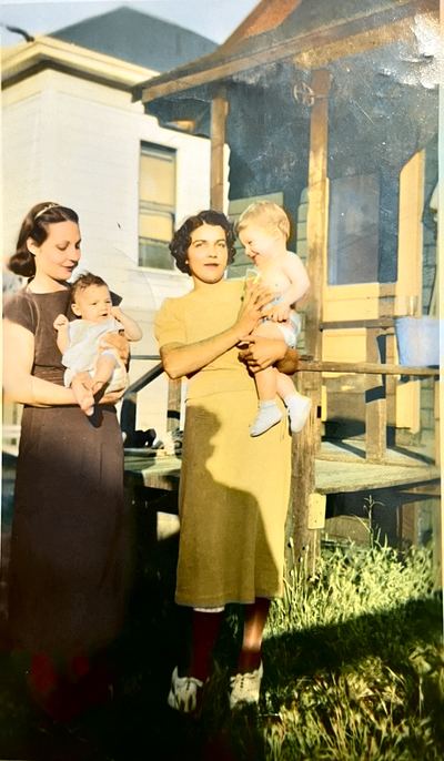 Restored and colorized (AI-assisted); faces are the original photo, colours are a best guess. Mable (Dubuque) Proeger holding Nancy, and Aileane Silva holding Dickie, c. summer 1937 — photograph courtesy of Sheryl (cousin) · Sheryl: "grandma holding little [Dickie] … and Mable holding mom"; the family called Richard Jr. "little Dickie"