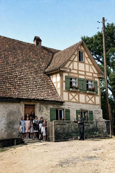 Restored and colorized (AI-assisted); AI-redrawn, colour a best guess (beams per Darian). The Pröger / Hintermeier house at Erkenbrechtshausen, photograph, about the 1930s (undated).