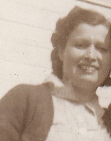 Mildred Rose Silva, smiling, with curled dark hair and a dark cardigan over a light blouse; detail from a three-generation family photograph