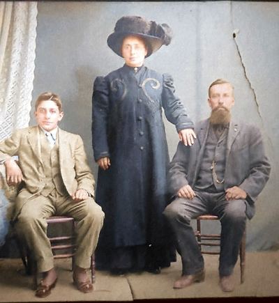Restored and colorized (AI-assisted); faces are the original photo, colours are a best guess. Frank Silva Sr, Anna L. Silva and Frank Silva Jr, studio portrait c. 1908-1912.